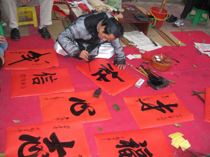 Ông đồ viết chữ lên giấy dó