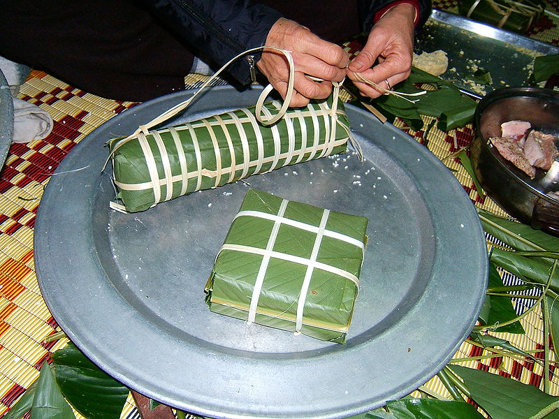 Một chiếc bánh chưng vuông và một chiếc bánh chưng tày vừa được gói
